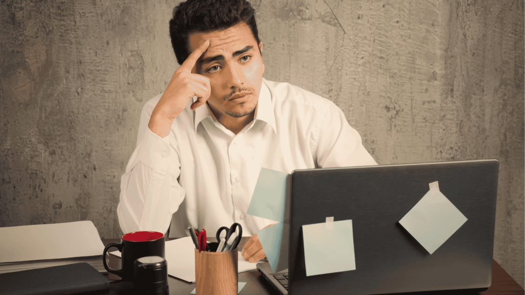 Homem sentado em sua mesa de escritório preocupado